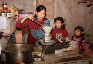 With her two daughters looking on, Amna Ahmed jars tangy pickles.