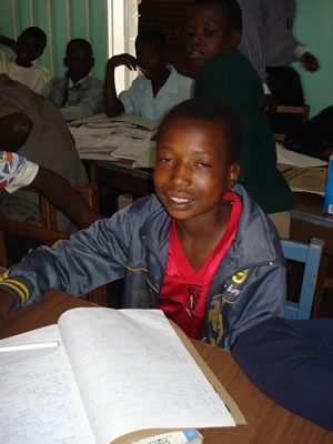 Lovemore studies at night in the streets. He hopes for a Presbyterian Children’s Club scholarship for boarding school. 