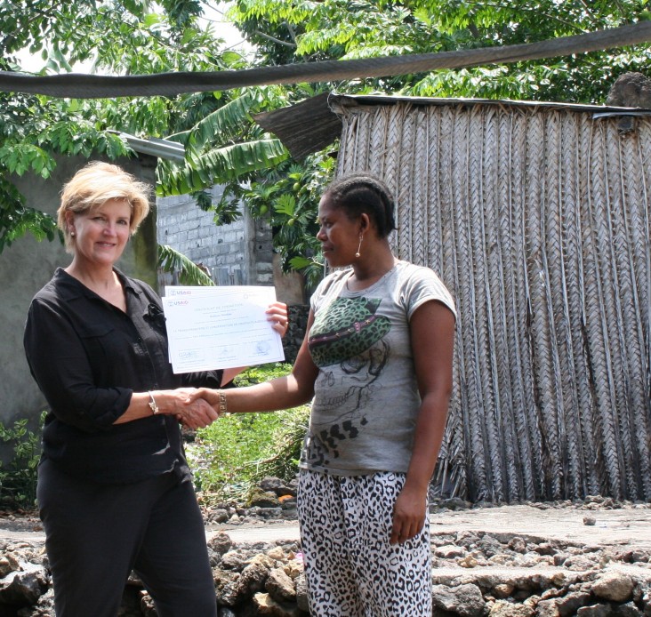 USAID Mission Director Susan Sawhill Riley presents a training certificate to Radiata Ibrahim