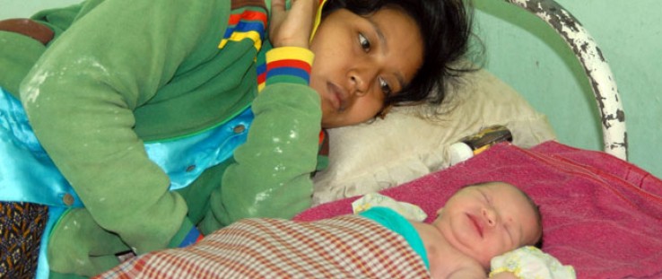 A mother with her newborn at a health center for post-partum care.