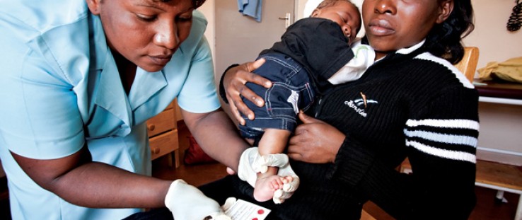 A nurse takes dried blood spot samples from an infant to test for HIV in a maternal and child health ward in a Malawi clinic.