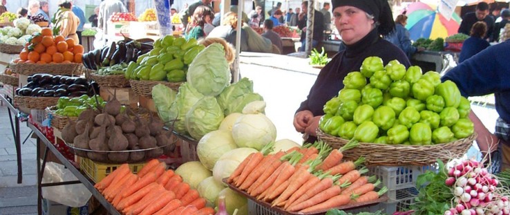 A woman sells vegetables at a local produce market in Georgia.