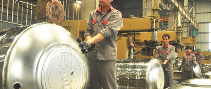 Employees at the Sonha Corporation produce stainless steel water tanks in Hanoi. 
