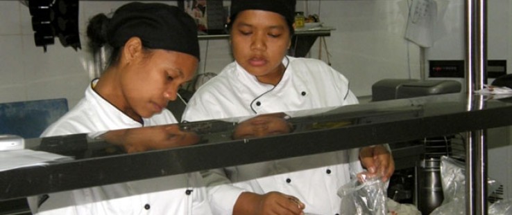 Ana Florinda da Costa (left), 25, who got her job through a USAID internship program, works with a colleague at the Discovery In