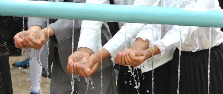 Children experience clean water running through their hands.