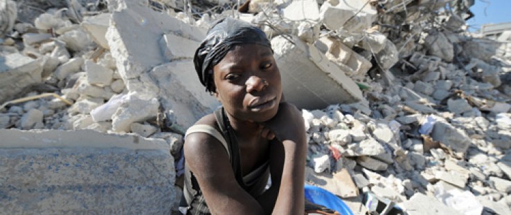 A Haitian woman rests on the rubble of a destroyed building at a market in Port-au-Prince following a massive 7.0-magnitude quak