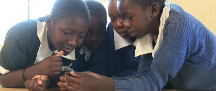Kenyan students play a mobile game.