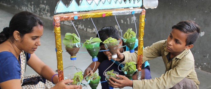 A teacher helps students perform a science experiment at Kavi Kalidas Primary School.