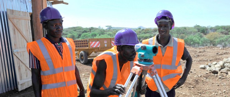 Workers survey a biomass site in Kenya.
