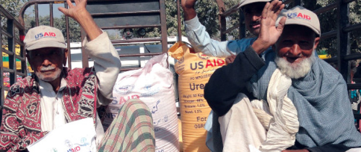 Punjabi farmers return home after receiving 50-kilogram sacks of wheat seed, fertilizer, and vegetable seed as part of USAID's $