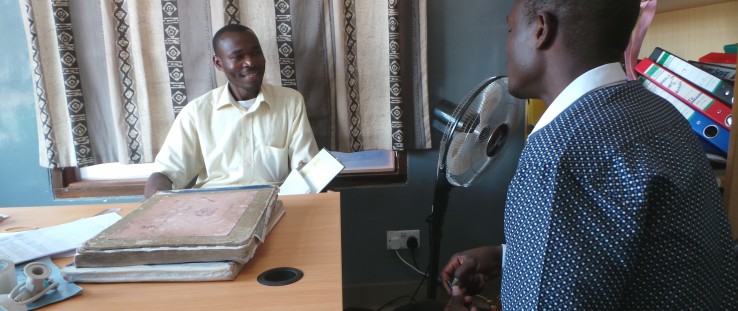 Misozi Banda, left, reviews referrals for the day with Martin Banda,