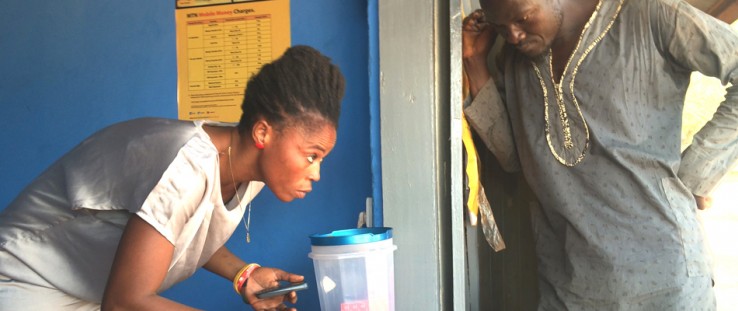 Sylvia Awuni helps a client make a mobile money transaction.