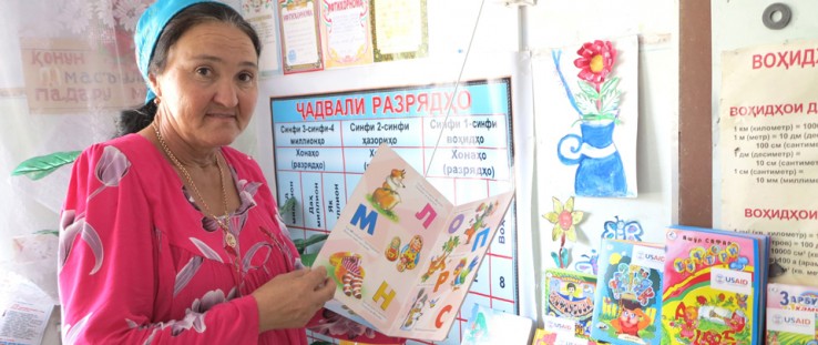 A school librarian shows off books at a library in Tajikistan established by USAID.