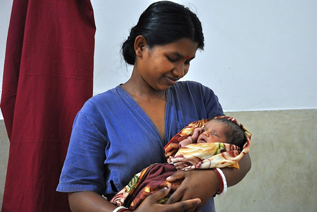 A health worker holds a newborn child