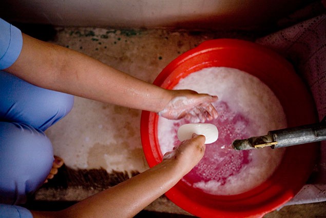 A woman washes her hands with soap and water