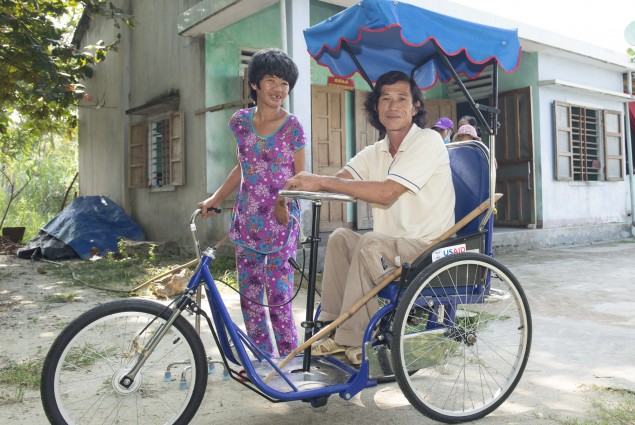 A person with disabilities in Quang Nam province on a tricycle wheelchair provided with USAID support.