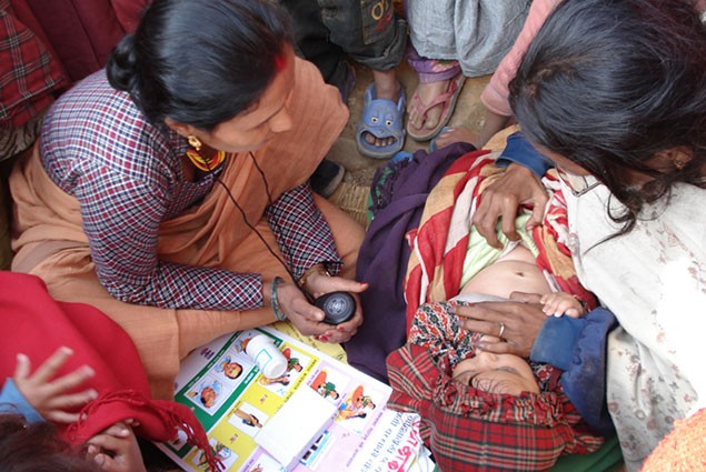 A health worker checks on the health of a young child