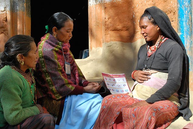 A new mother sits with others from her village