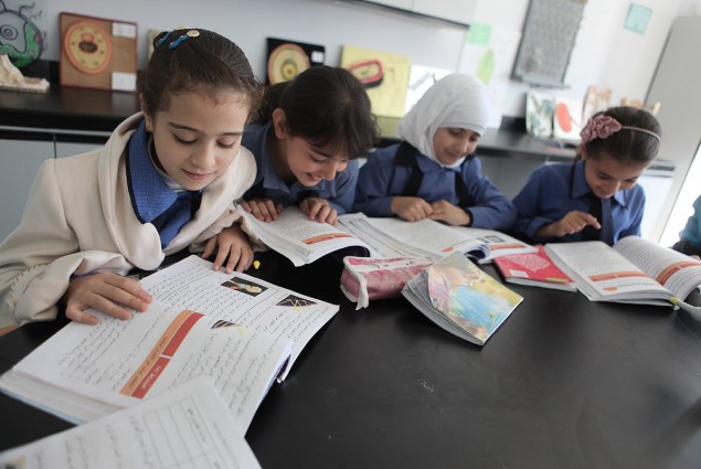 Young girls are hard at work studying history a USAID-funded school.