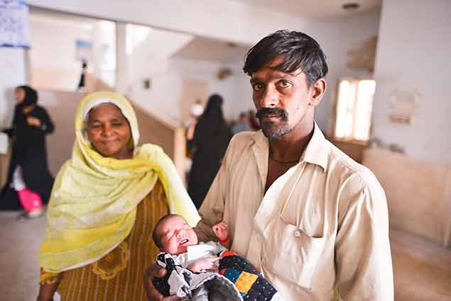 A father holds his new born child in Pakistan