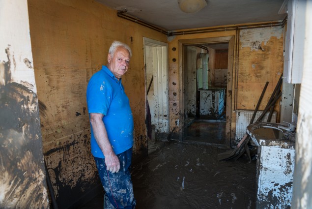 Maglaj man stands in his living room, preparing to clear mud left behind after devastating floods in Bosnia in May 2014.