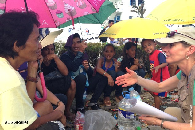 USAID Assistant Administrator Nancy Lindborg with evacuees outside Tacloban airport. Evacuees are flown to Manila aboard militar