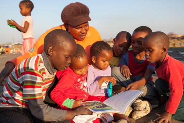An Isibindi child and youth care worker reads to children