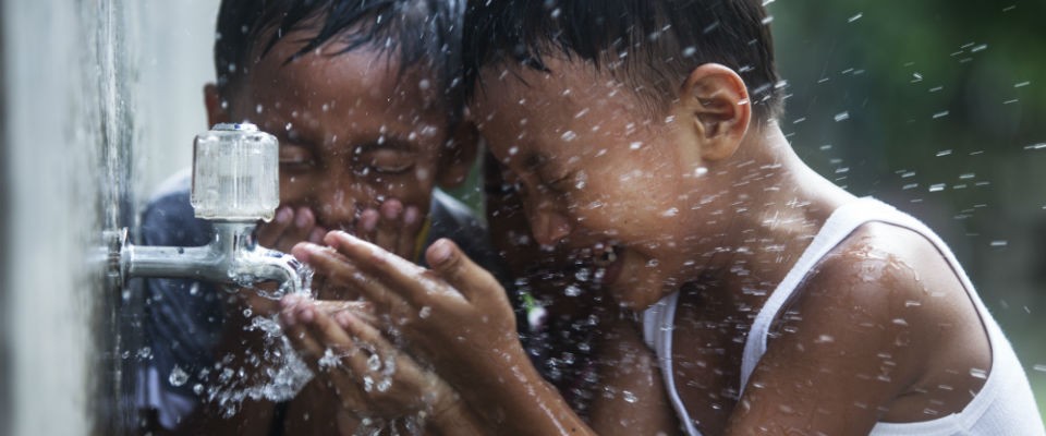 Anak-anak sedang mencuci muka mereka dengan air setelah bermain