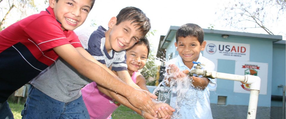 Children playing with water during a water system inauguration in La Lima.