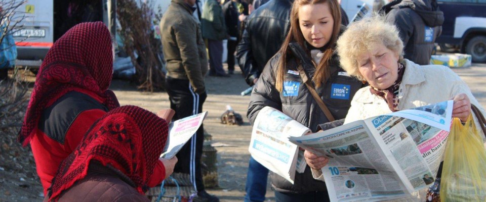 A volunteer distributes newspaper supplements on EU integration to residents of a Moldovan village. 