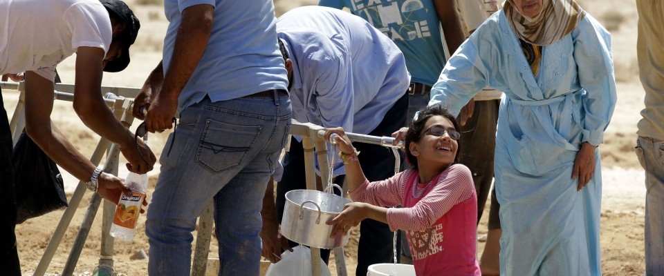 Syrian refugees collecting water at a refugee camp in Jordan near the border with Syria.