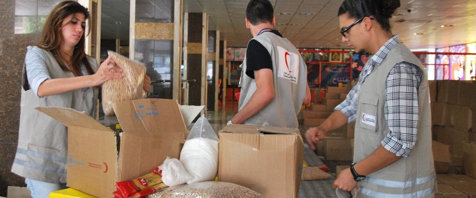 Image of Syrian Red Crescent staff filling boxes of food for internally displaced people.