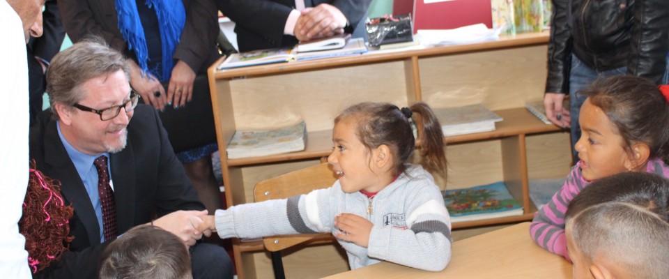 Drejtori i misionit James Hope në bisedë me fëmijët gjatë vizitës së bërë një qendre të mësimit për fëmijët e komunitetit Roma, 
