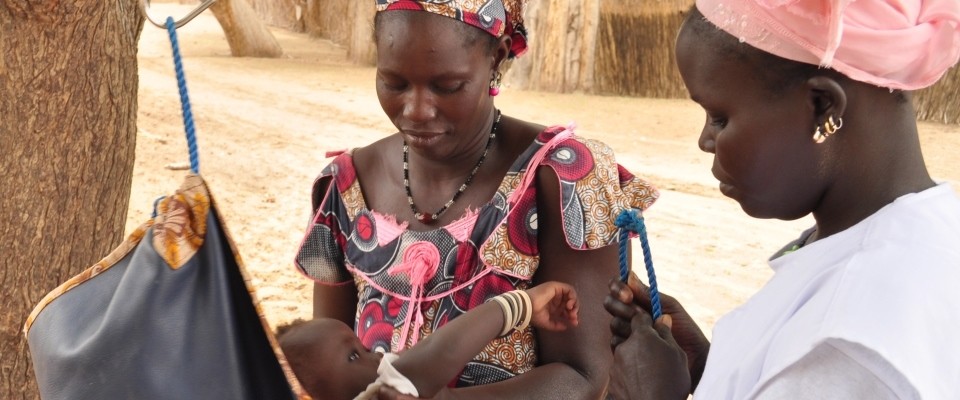 Mbène Dionne weighs village babies to ensure they are not underweight