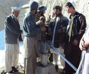 A newly trained mechanic is fixing a nonfunctioning hand-pump with community support in Paktia Province.
