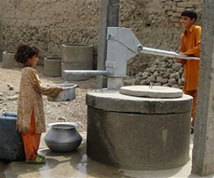 Children pump clean water at a communal tap connected to the USAID-funded pipe network in Nawa village.