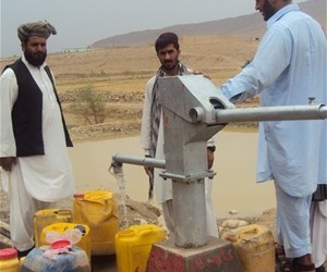 Al-Temor community members collect clean drinking water from a well recently constructed by USAID.
