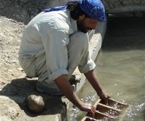 A laborer in Khar Lando Village cleans a karez leading to the canal.