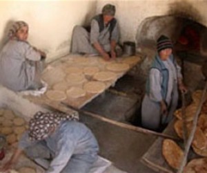 Afghan women prepare flatbreads at a bakery.