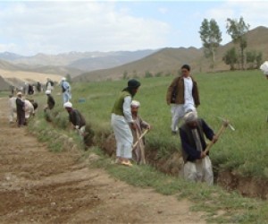 Ghor residents gravel a road and dig a drainage ditch to prevent flooding. Improved roads allow better access to markets, school