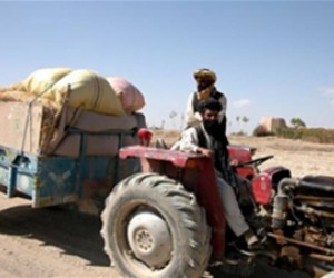 Abdul Aquil, at the wheel of his tractor, brings crops to market on the Jaghatu to Rashidan road. "The road increases trade betw
