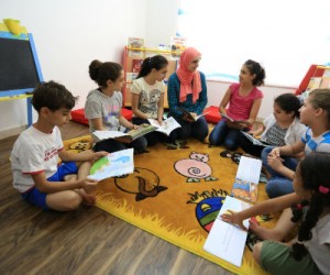 Children discuss stories they read in their weekly book club meeting with Eman Awamleh, founder of Carnaval Play & Learn.