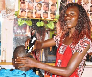  Mildred Wanjala attends to a customer at her Bungoma County barbershop