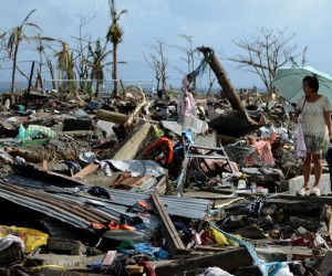 A survivor walks among the debris of houses destroyed by Super Typhoon Haiyan in Tacloban in the eastern Philippine island of Le