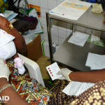 A health worker collects dried blood samples from an infant 