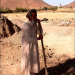 Mohammed Shah, one of five area farmers invested in a shallow well in Logar, pauses to chat while harvesting onions.