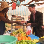 Christopher La Fargue, a USAID Food For Peace officer, buys fruit at Honorine’s food stand