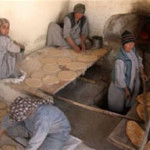 Afghan women prepare flatbreads at a bakery.