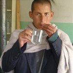 Wasil, a 17-year-old diagnosed with tuberculosis, takes his medication at a USAID-assisted health clinic.