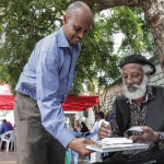 Abdilatif Ega, a renowned international author at the Mogadisihu Book Fair, signs a copy of his novel ‘Guban.’ 